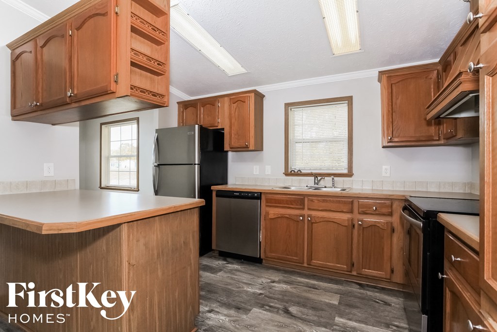 a kitchen with wooden cabinets and a sink and a refrigerator