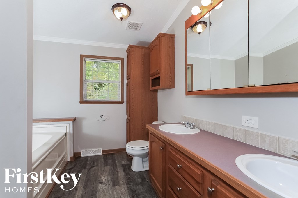 a bathroom with a toilet sink and mirror and a tub