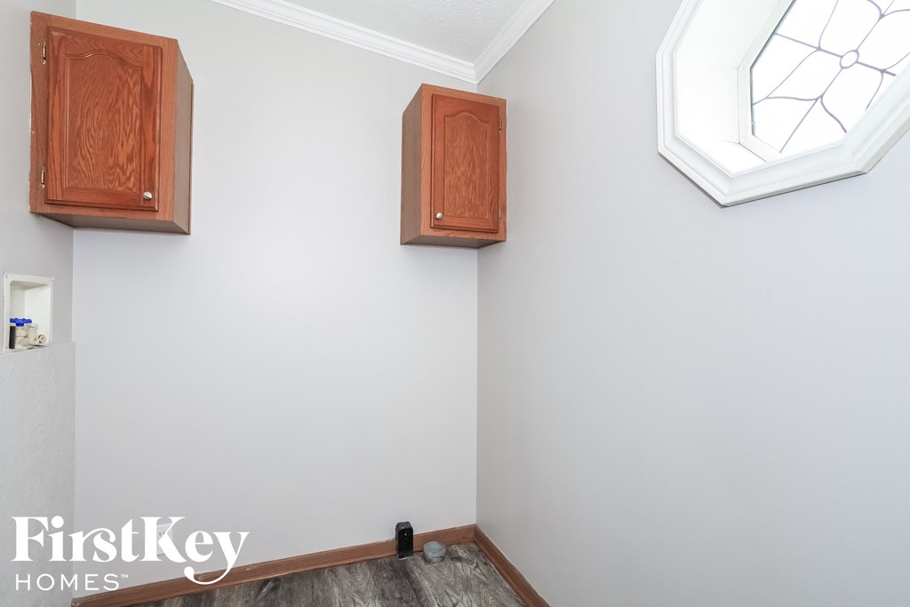 three cabinets on the wall in a white room with a window
