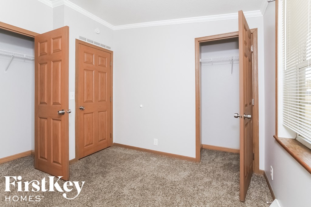 a bedroom with two closets and two doors