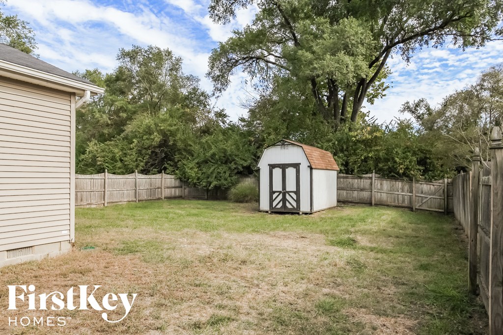 a backyard with a chicken coop and a shed in the yard