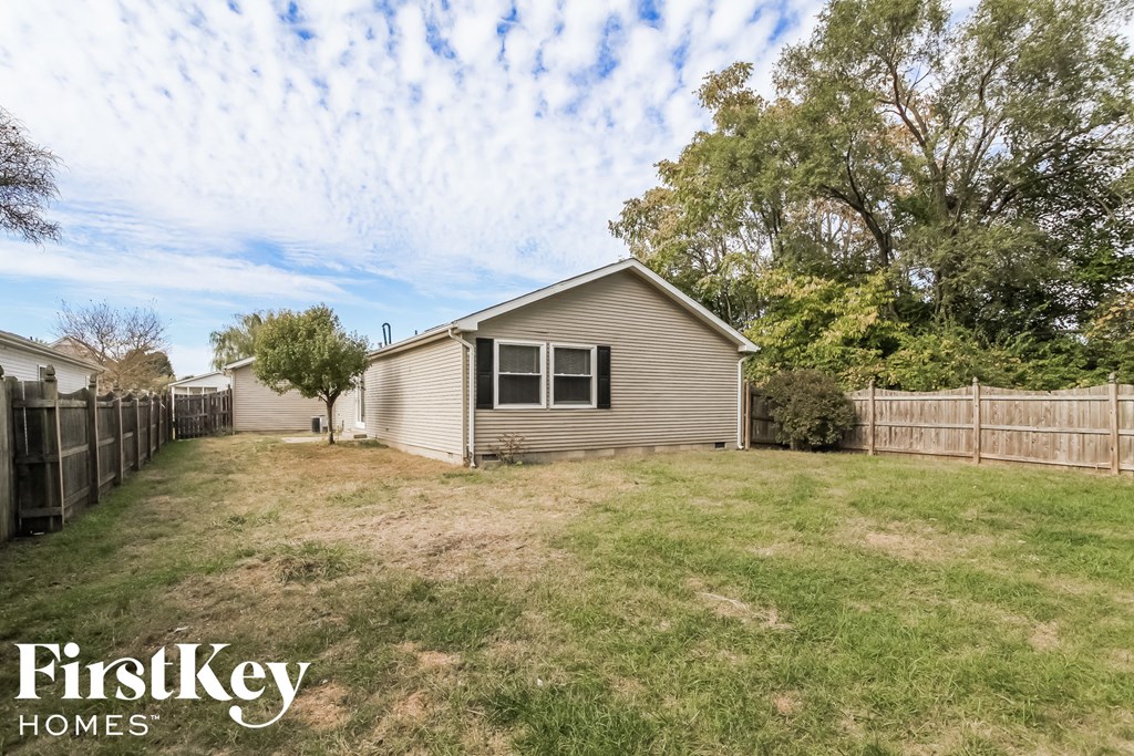 a home with a yard and a fence and a house