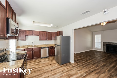 A kitchen with wooden cabinets and a refrigerator.
