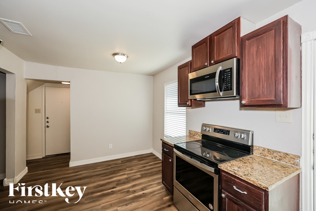 A kitchen with wooden cabinets and a granite countertop.