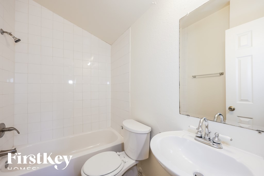 A white bathroom with a toilet, sink and bathtub.