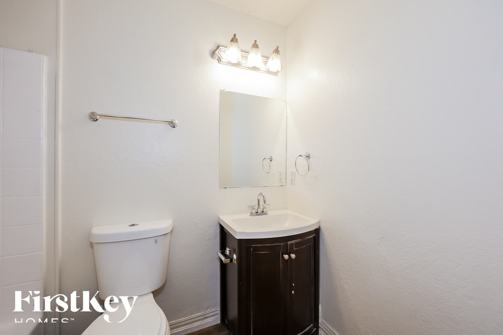 A white toilet sits next to a sink in a small bathroom.