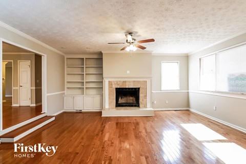 A spacious living room with a fireplace and built-in shelves.