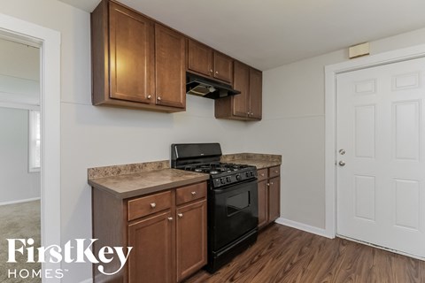 a kitchen with wooden cabinets and a stove and a black oven