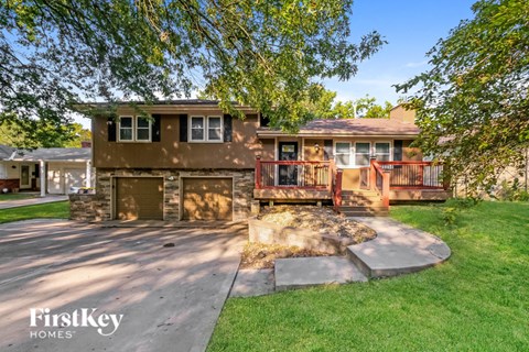 a house with a patio and a driveway in front of it