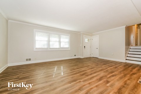 the living room of an empty house with wooden floors and white walls