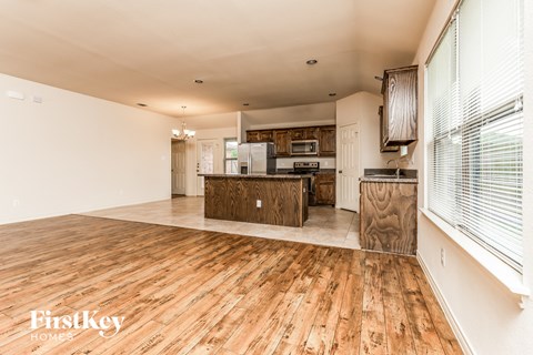 a kitchen and living room with wood floors and white walls