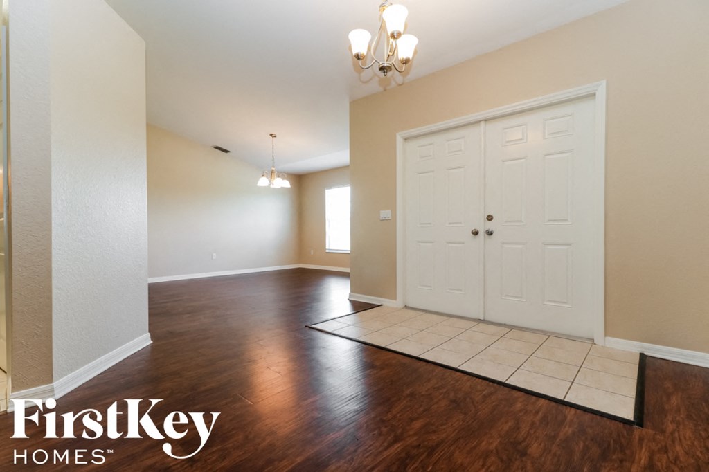 A room with a wooden floor and a chandelier.