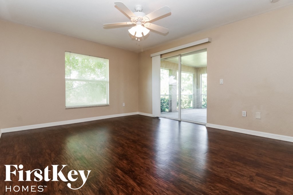 A room with wooden floors and a ceiling fan.