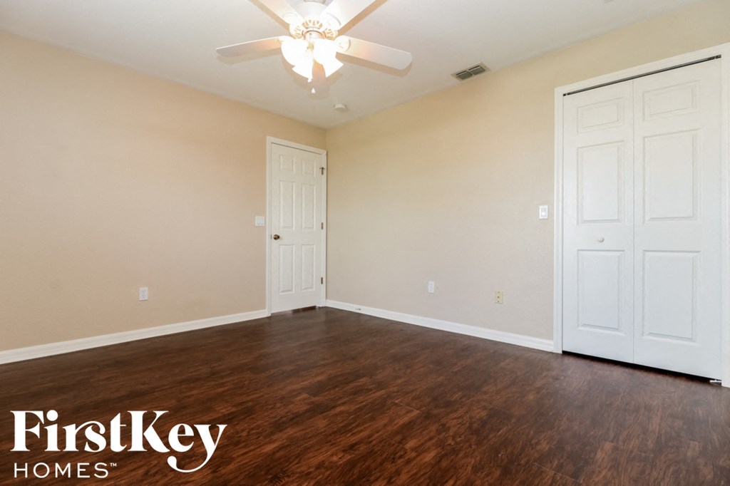 A room with a ceiling fan and two doors.