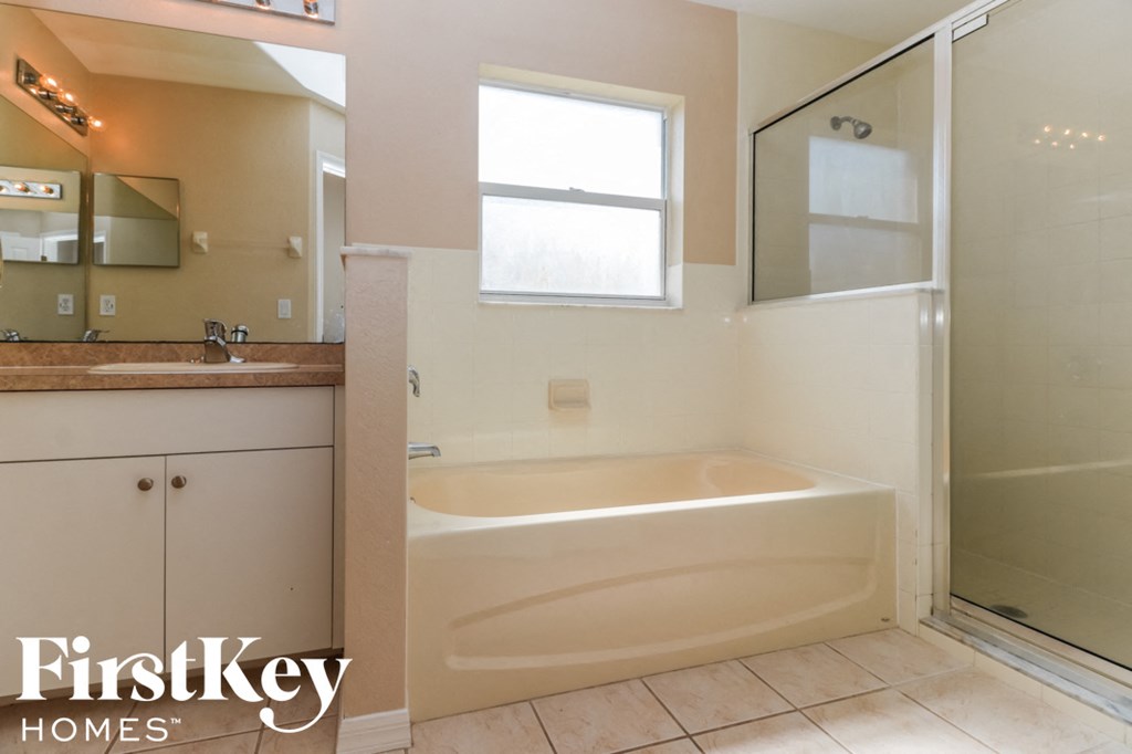 A bathroom with a tub, sink, and shower.
