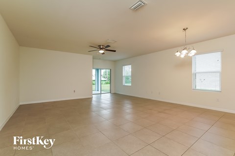 A spacious room with a ceiling fan and tiled floor.