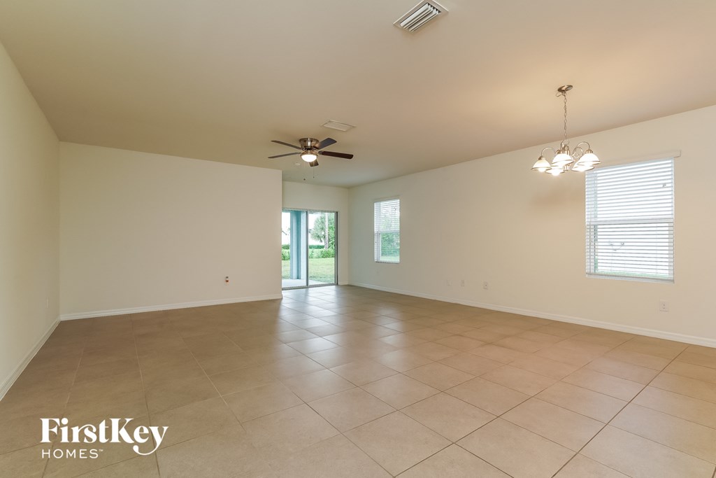 A spacious room with a ceiling fan and tiled floor.