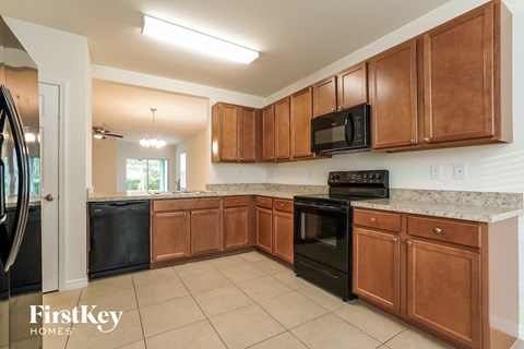 A kitchen with brown cabinets and black appliances.