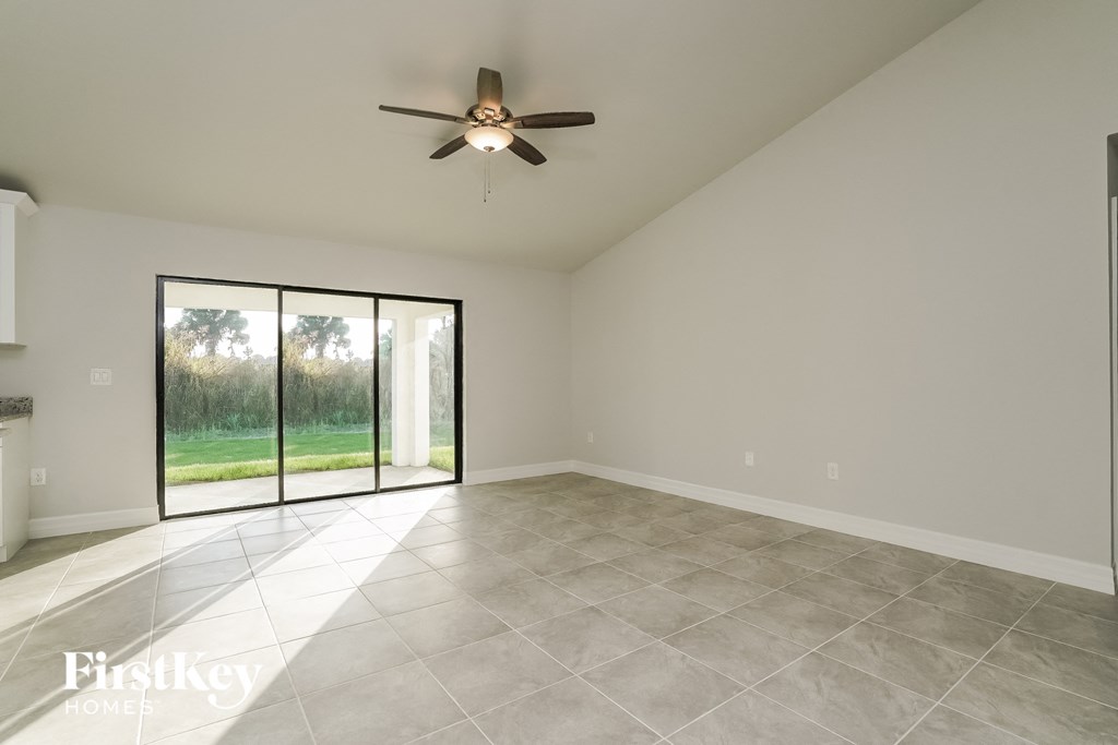 A spacious room with a ceiling fan and sliding glass doors.