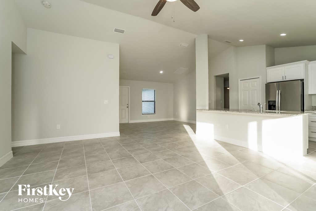 A spacious, empty room with a fan and a window.