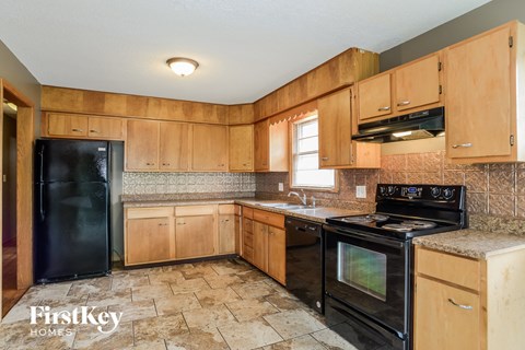 A kitchen with wooden cabinets and black appliances.