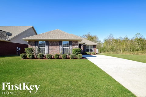 a brick house with a sidewalk in front of it