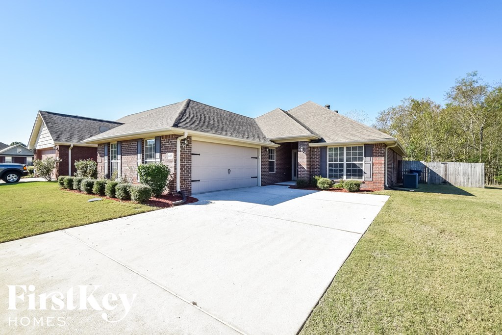 a home with a white driveway in front of a house