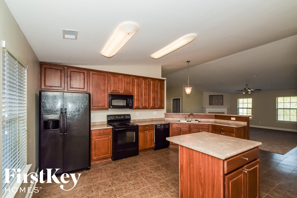 a kitchen with wooden cabinets and black appliances