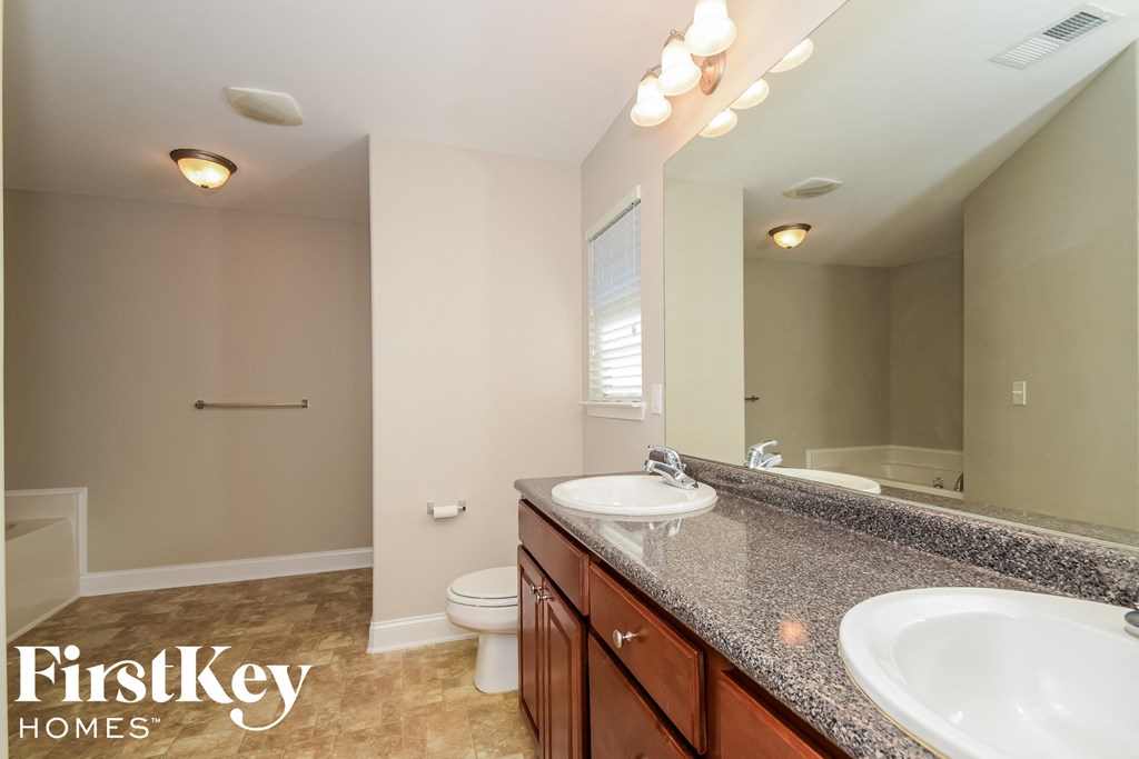 a bathroom with two sinks and a toilet and a mirror