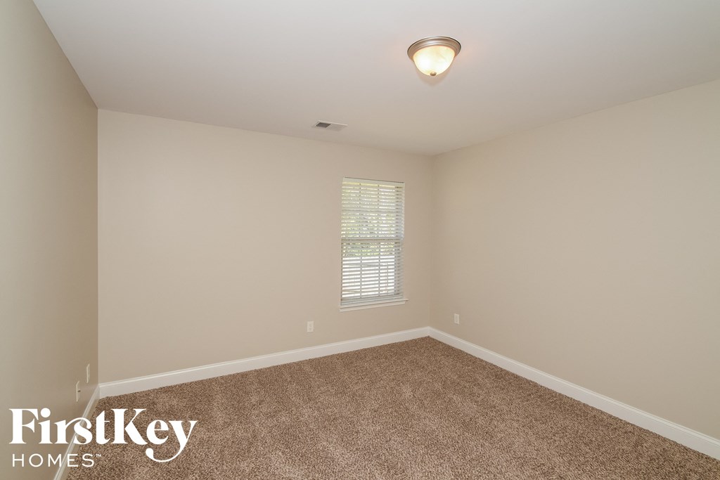 the second bedroom is spacious and has carpeting and a window