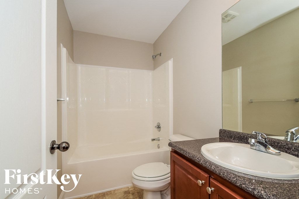 a bathroom with a shower toilet and sink and a mirror