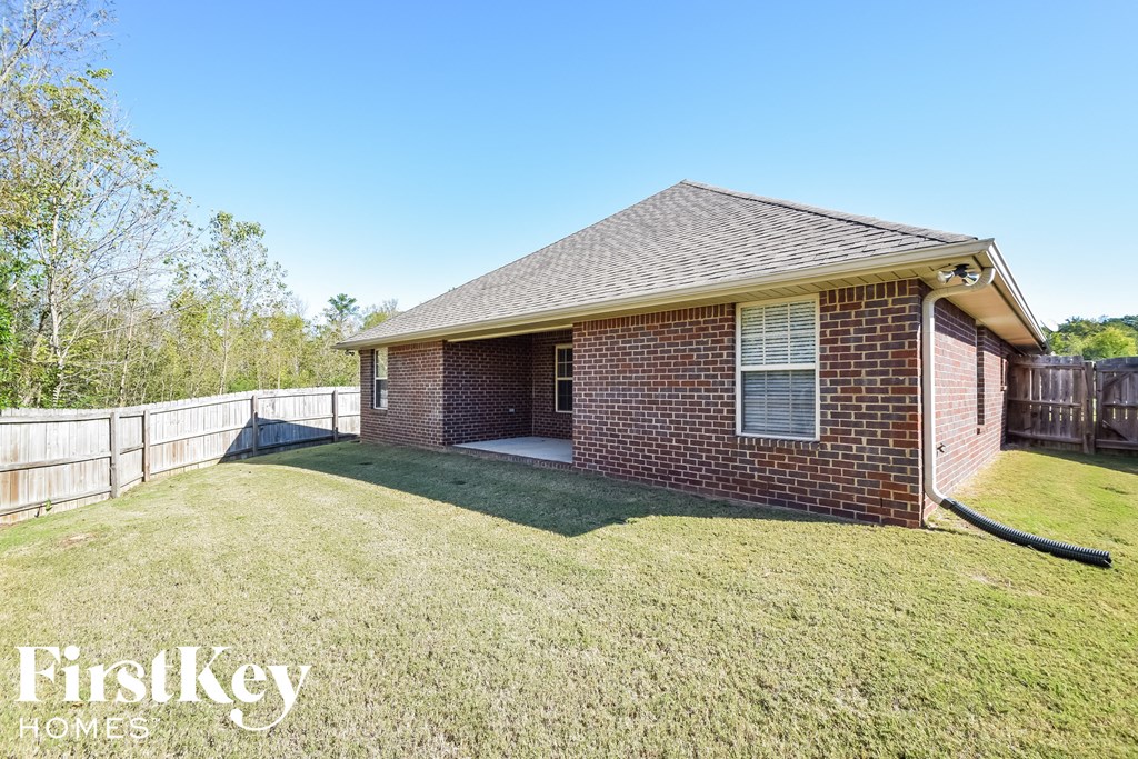 a backyard with a brick house and a fence