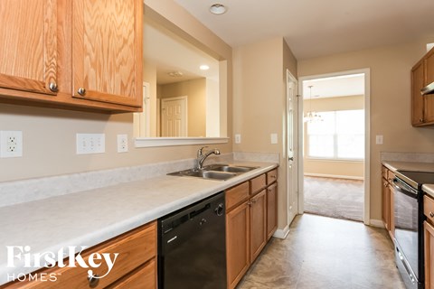 A kitchen with wooden cabinets and a marble countertop.