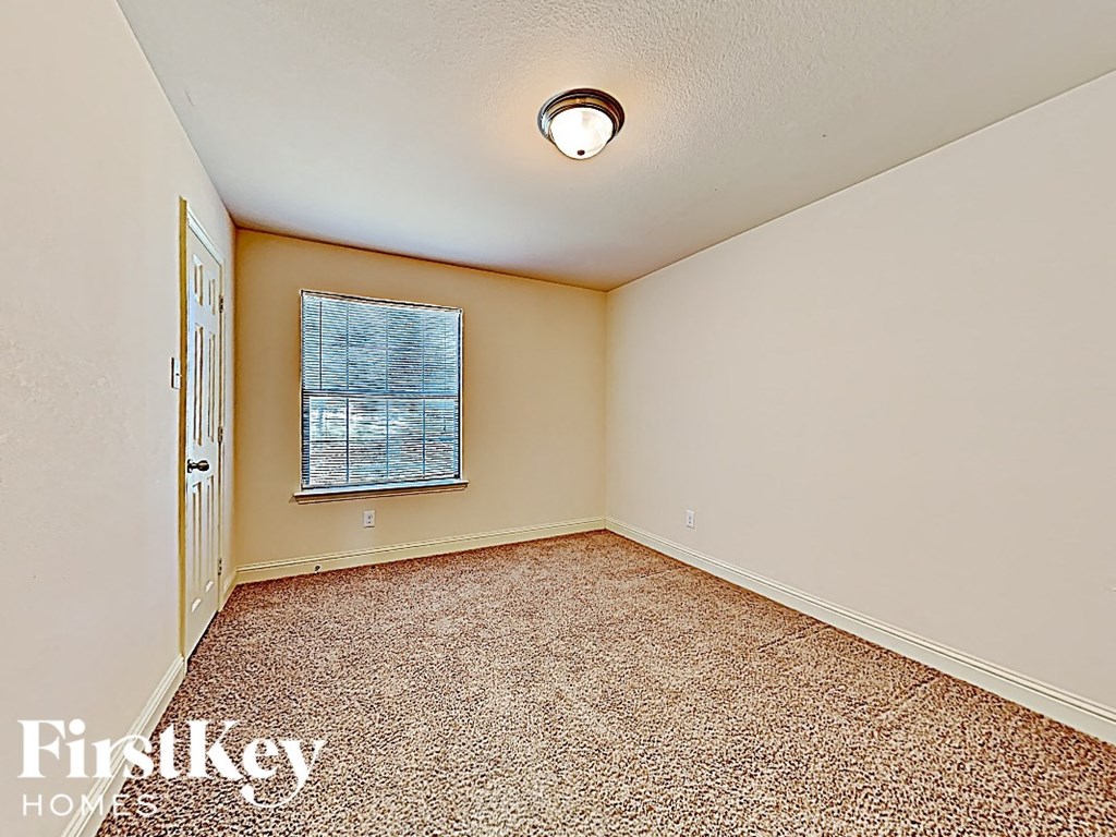 an empty living room with carpet and a window