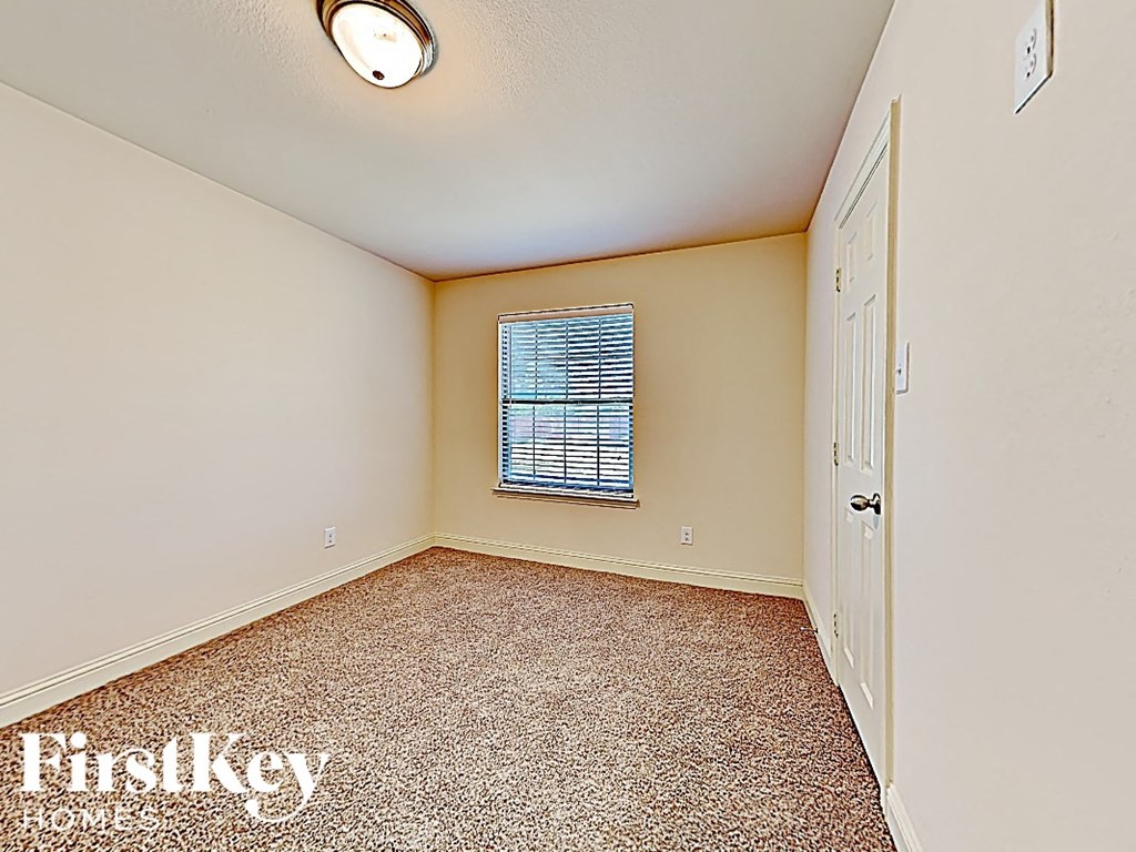 an empty room with a window and a white door