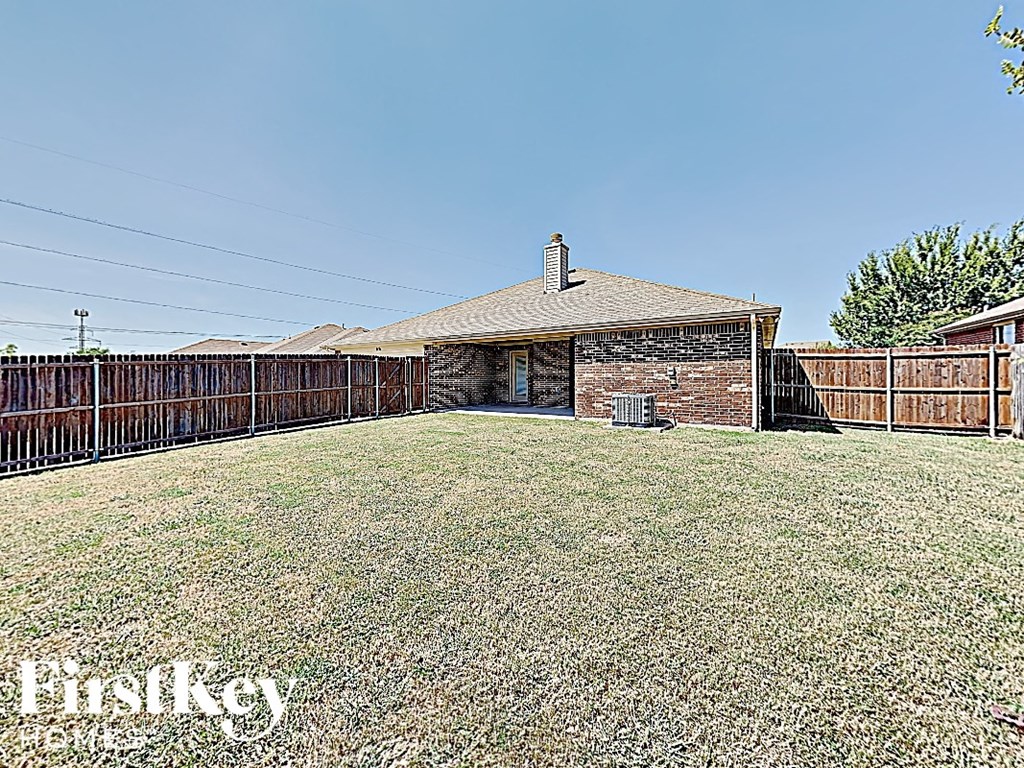 a backyard with a fence and a house with a yard