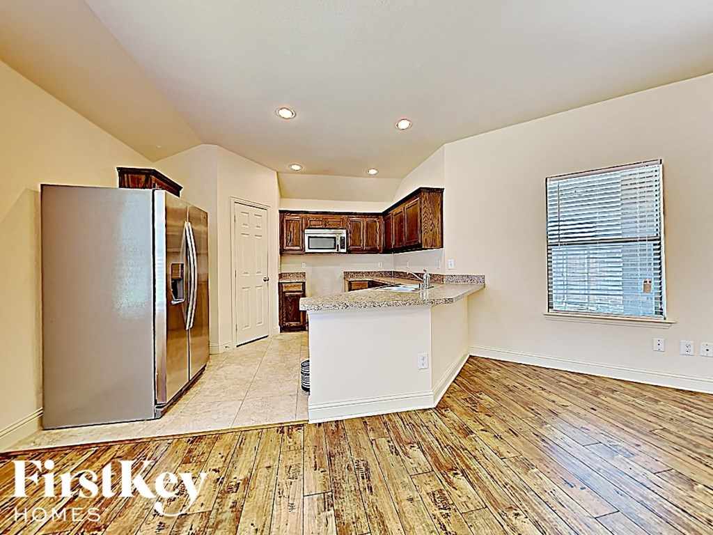 an open kitchen with stainless steel appliances and wood flooring