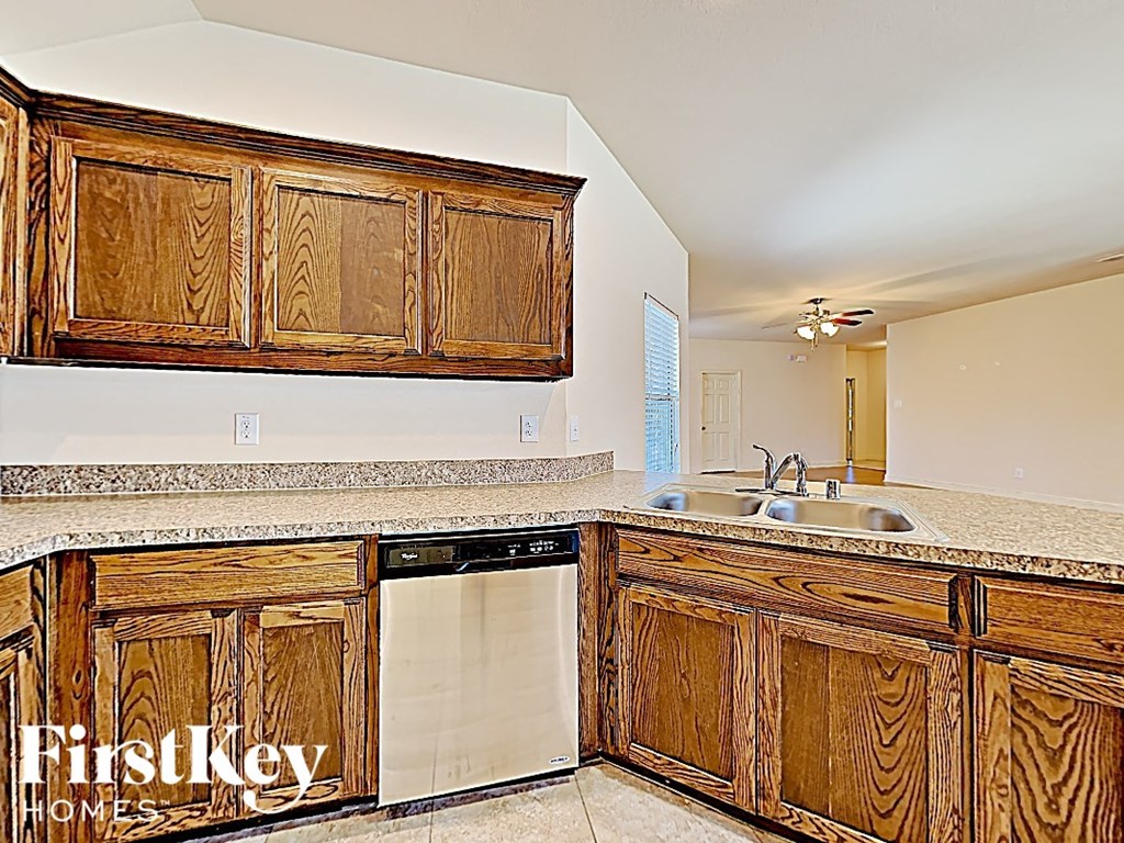 a kitchen with wooden cabinets and a dishwasher and a sink