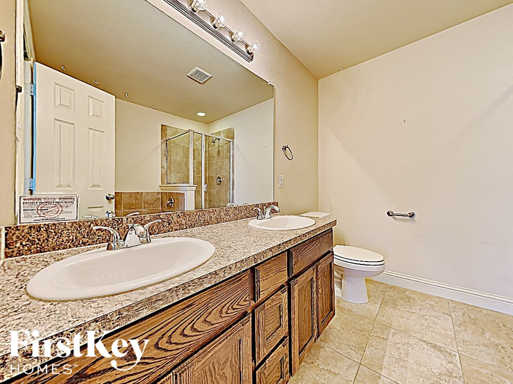 a bathroom with two sinks and a toilet and a mirror