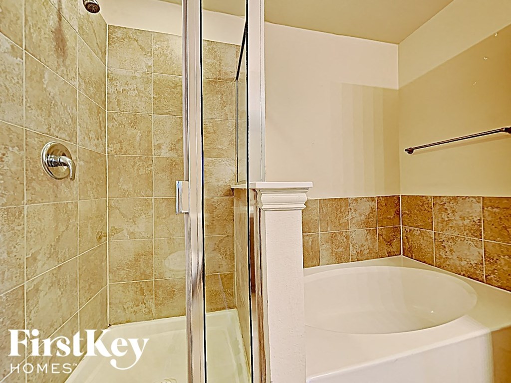 a bathroom with a shower and a bath tub