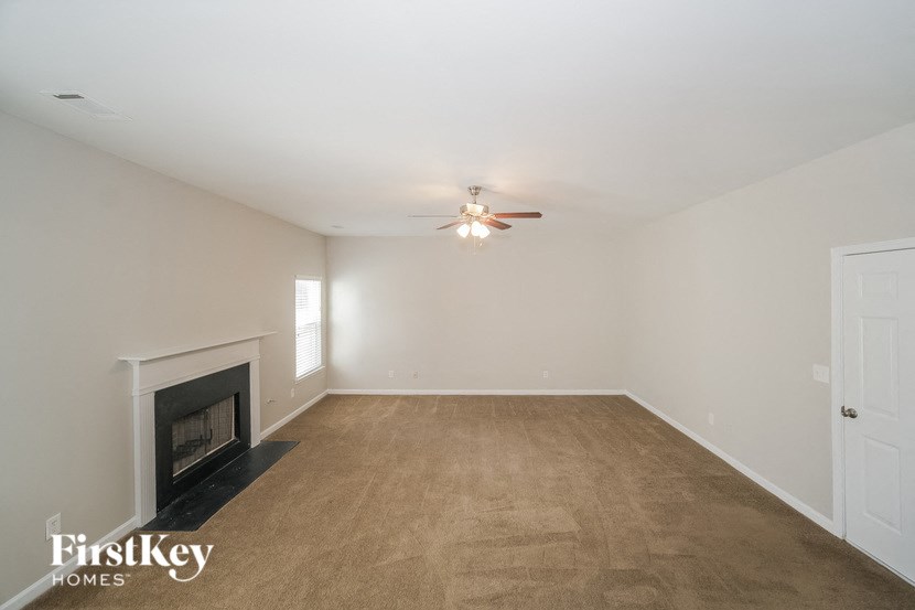 a living room with a fireplace and a ceiling fan