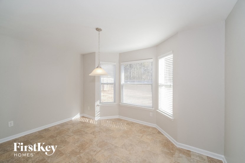 a dining room with a large window and a pendant light