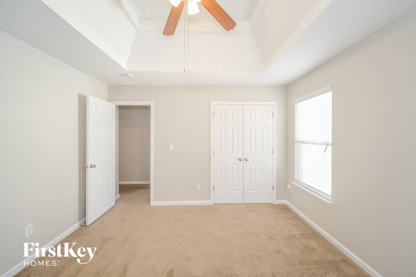 a bedroom with two closets and a ceiling fan