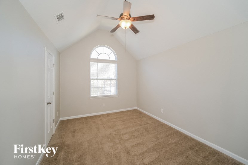 a bedroom with a ceiling fan and a window