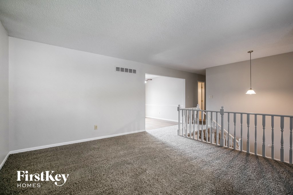 the upstairs living room and dining room of an empty house