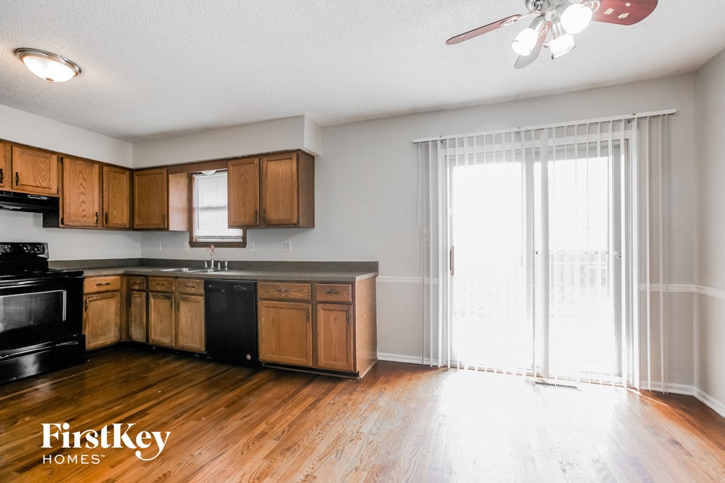 a kitchen with wooden cabinets and a sliding glass door