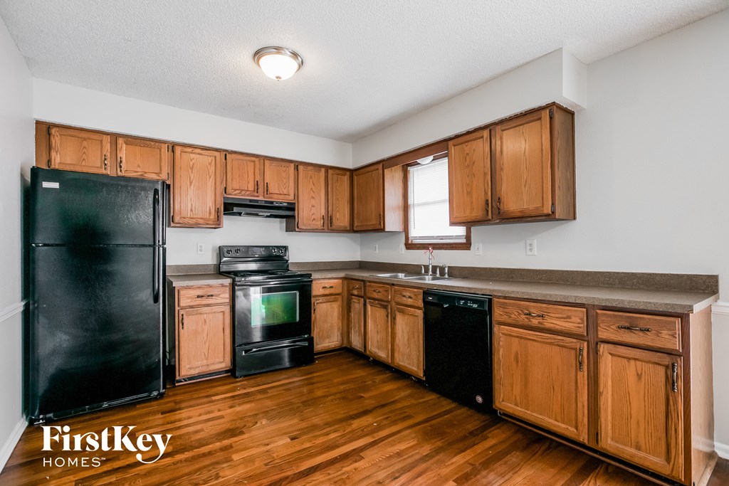 a kitchen with wooden cabinets and black appliances