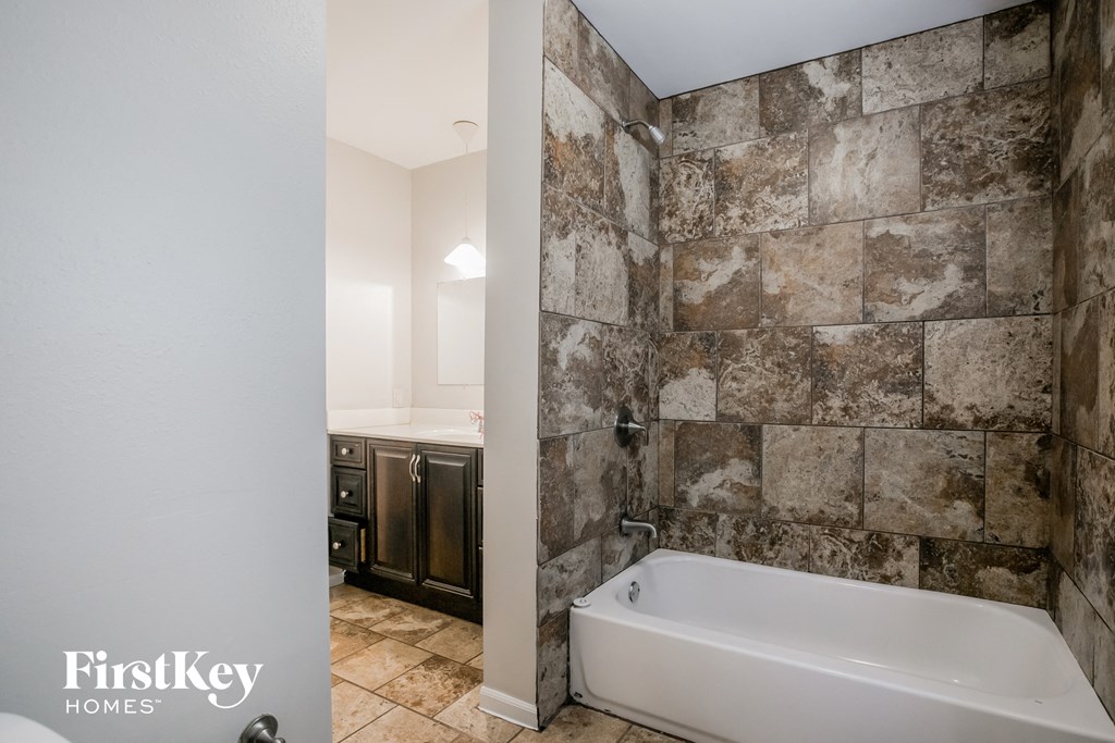 a bathroom with a tub and a shower and a sink