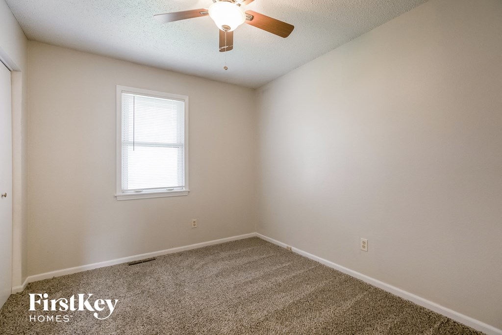 a bedroom with carpet and a ceiling fan