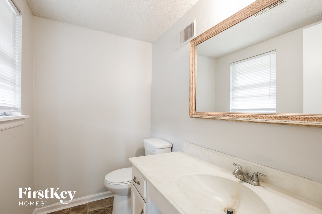 a bathroom with a sink toilet and a mirror